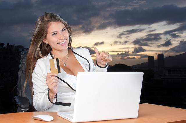 femme contente tenant une carte de crédit, passer une commande par Internet, black friday, cyber monday