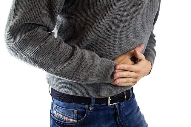 homme qui tient son ventre à cause d'un problème de digestion