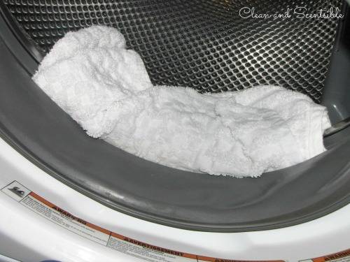 serviette imbibée d'eau et d'eau de javel dans le joint de la porte de la machine à laver