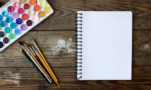 palette d'aquarelle, cahier de dessin et pinceaux