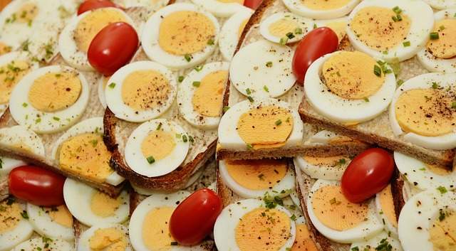 œufs durs coupés sur des tranches de pain avec des tomates
