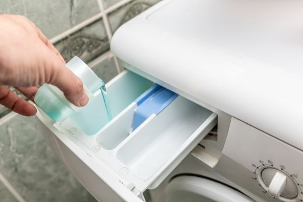 Verser lessive dans le bac de la machine à laver