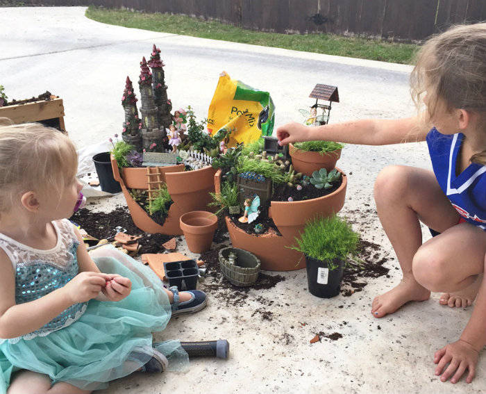 enfants qui décorent des pots de fleurs