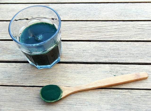 cuillère de spiruline et verre d'eau avec des spiruline