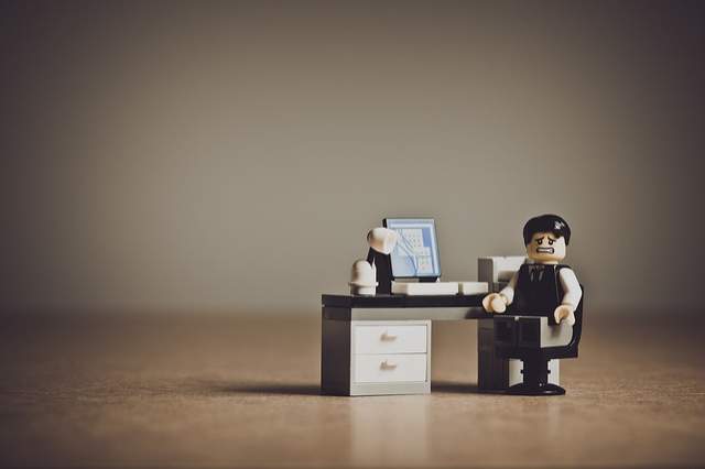 personnage mécontent assis à un bureau