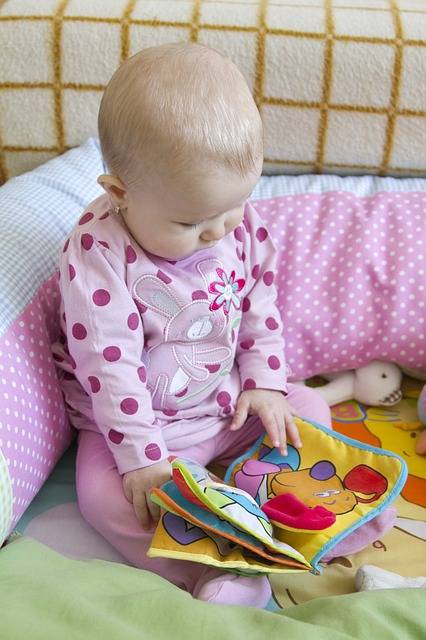 bébé en train de feuilleter un livre en tissu