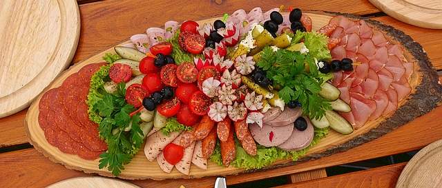 magnifique plateau de charcuterie sur un rondin de bois avec des légumes et des olives faire un beau plateau de charcuterie