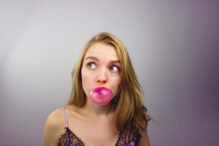 femme qui fait une bulle avec un chewing-gum