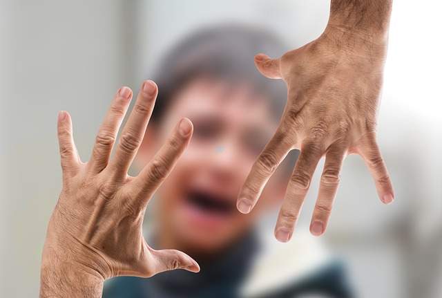 Violence enfant qui pleur mains menaçantes 