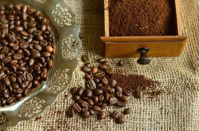 graines de café et tiroir de moulin avec du café moulu