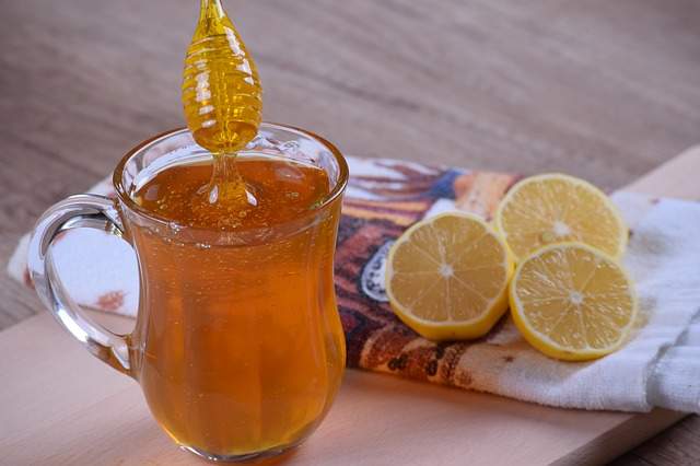 miel dans une tasse en verre et rondelles de citron