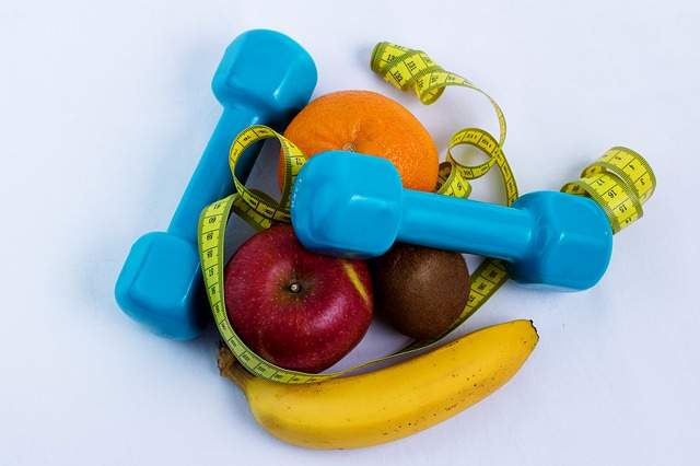 haltères, mètre ruban et fruits, régime amincissant et sport