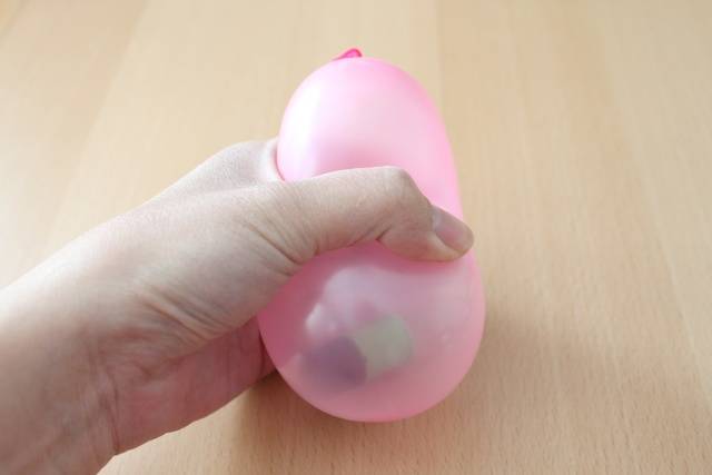 Presser un ballon de baudruche pour lui donner une forme ovale
