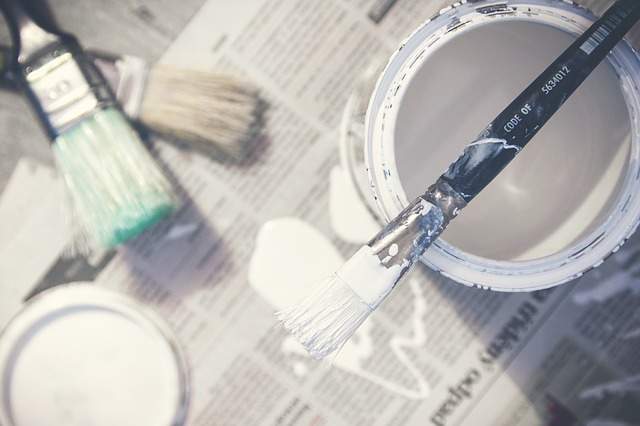 pot de peinture pinceaux sol protégé avec de vieux journaux