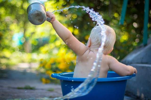 bébé joue dans l’eau