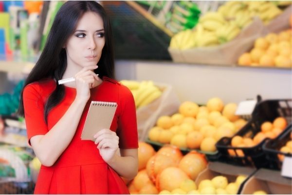 femme au marché avec une liste de courses