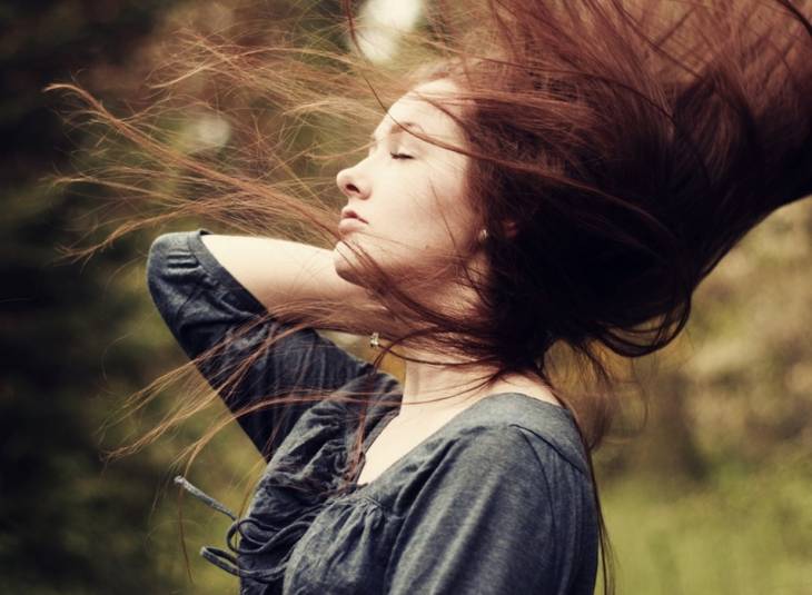 fille dans la nature cheveux aux vents sous le soleil