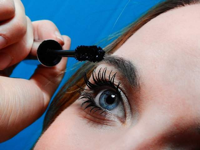 femme qui se maquille avec du mascara 