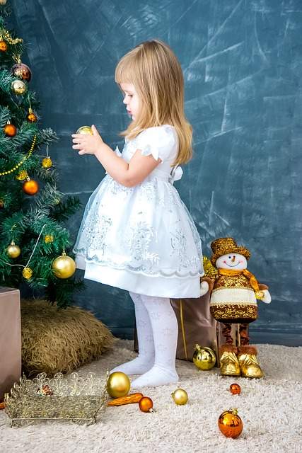 Petite fille qui décore le sapin de Noel