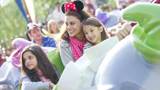 mère et ses deux filles dans une attraction à Disneyland