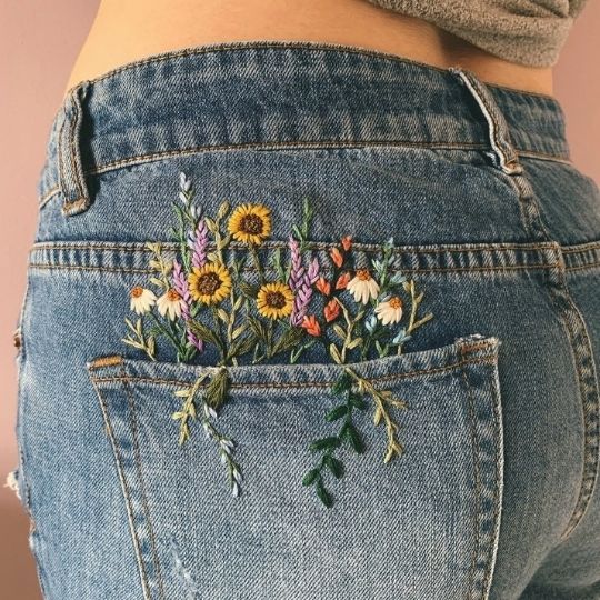 Un bouquet de fleurs sur la poche d’un jean