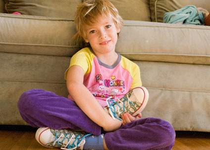 enfant souriant avec des chaussures à lacets