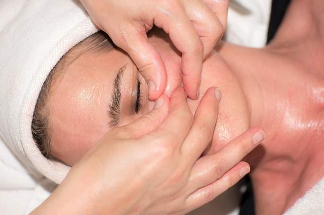 femme chez l'esthéticienne entrain d'avoir un massage du visage