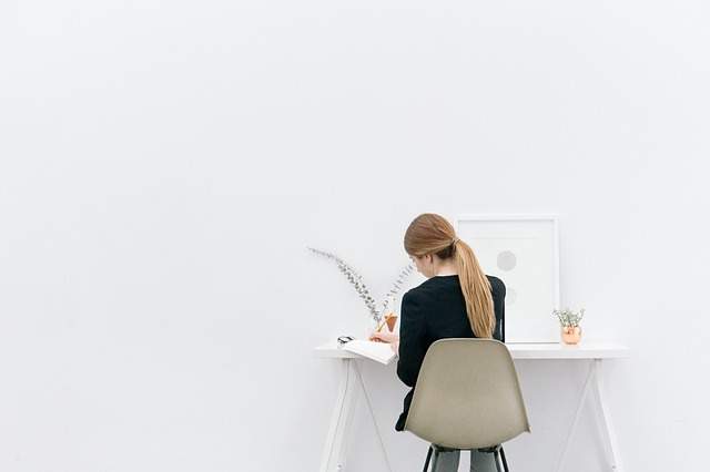 femme assise de dos à un bureau