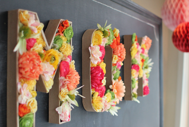 Lettre en papier maché décorée avec des fleurs artificielles