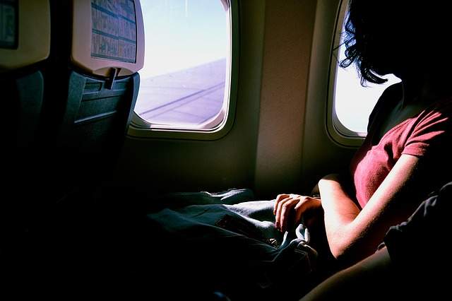 femme assise à côté du hublot dans un avion