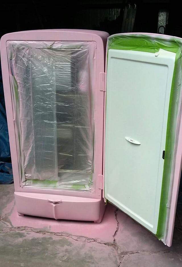 vieux réfrigérateur entrain d'être repeint en rose