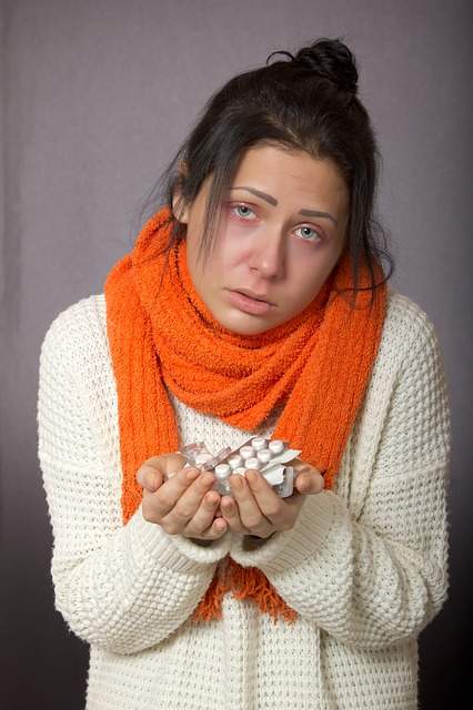 femme grippée qui tient des comprimés