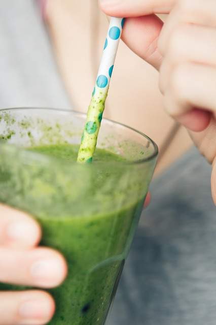 green smoothie dans un verre avec une paille