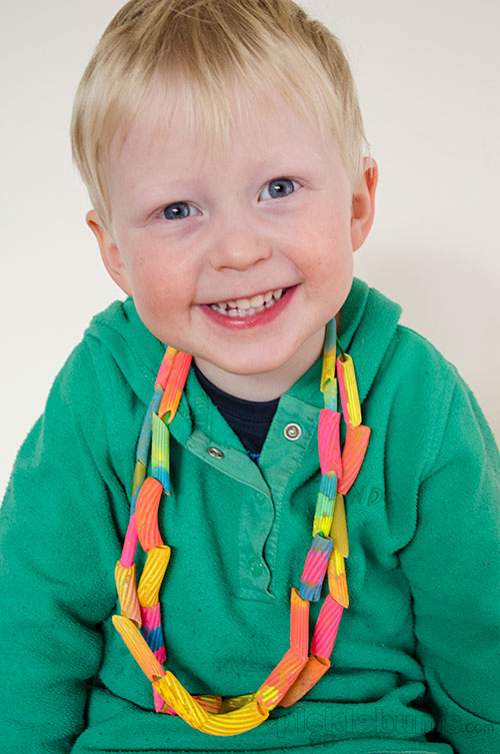 enfant portant les colliers de pâtes