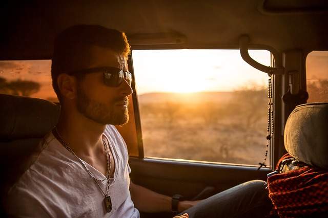 jeune homme avec des lunettes de soleil assis dans une voiture