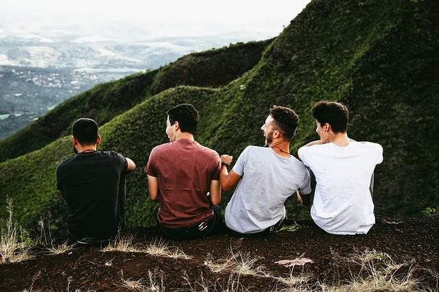 quatre amis assis devant des montagnes 