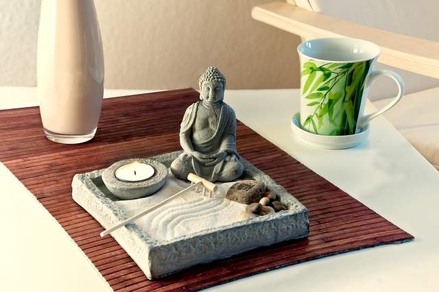 mini-jardin zen avec du sable et mug de thé vert