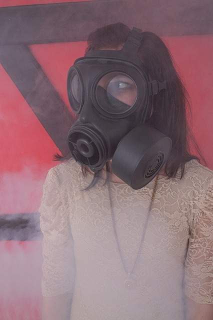 fille dans un nuage de fumée portant un masque à gaz