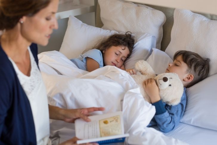 Une mère en train de lire une histoire à son enfant avant de dormir