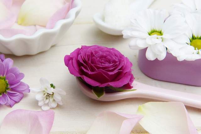 cuillère avec une rose et beurre de karité en arrière plan
