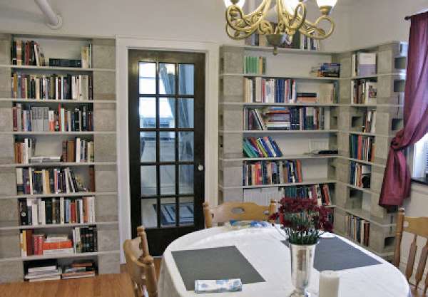 Une salle à manger avec une bibliothèque en parpaings et planches de bois