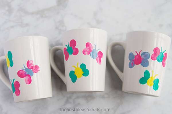 Des tasses ornées de papillons peints avec les doigts pour surprendre maman
