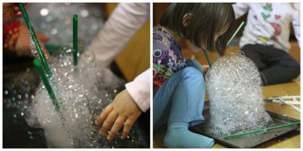 Montagnes de bulles avec du liquide vaisselle et des pailles en plastique