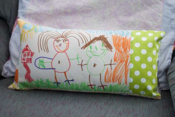 Un coussin avec un dessin d'enfant fait avec des feutres pour tissu