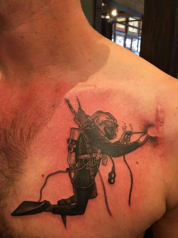 Un tatouage plongeur entrain de souder cette cicatrice
