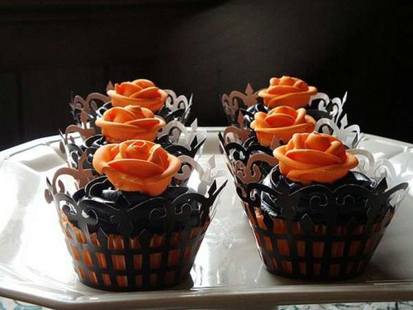 Glaçage noir et des roses oranges pour des cupcakes mystérieux