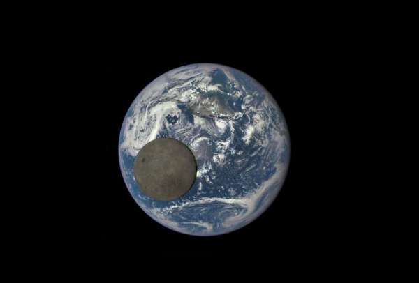 Le coté obscur de la lune qui passe entre la terre et un vaisseau spatial