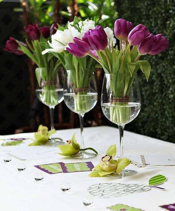 Centre de table pour Pâques avec des verres à vin transformés en vases pour les jolis bouquets de tulipes