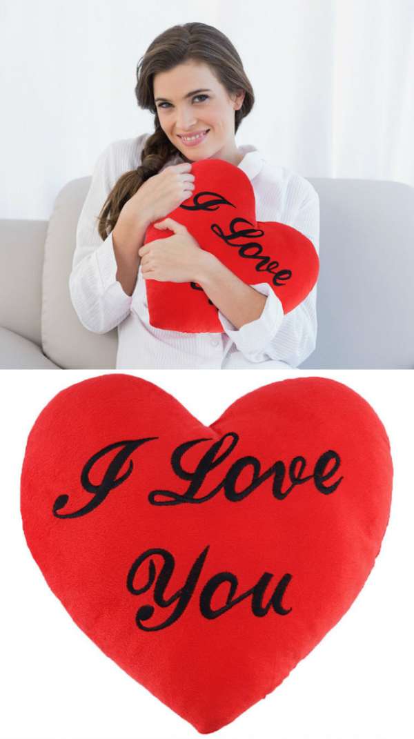 Un coussin en peluche en forme de cœur avec une inscription I Love You