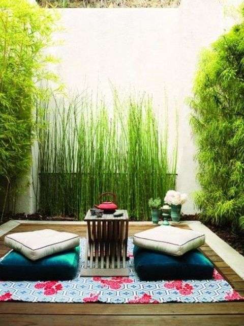 Idée de décoration de terrasse avec un tapis et des coussins de sol